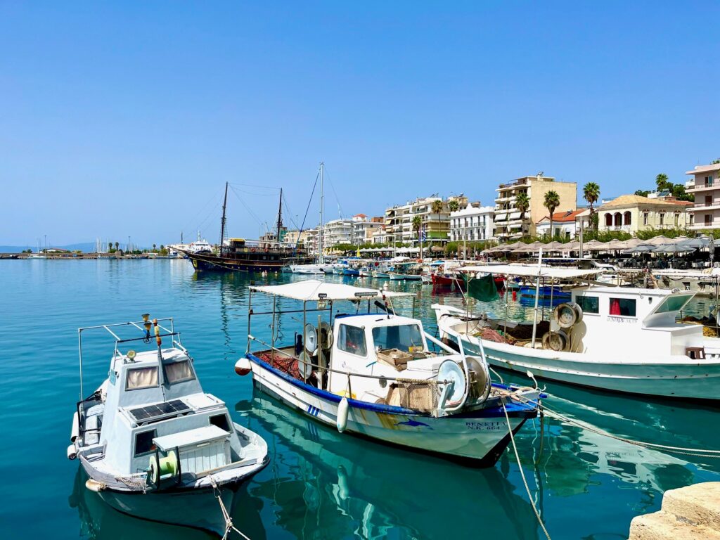 Turkost hav och vita båtar i Kalamata.