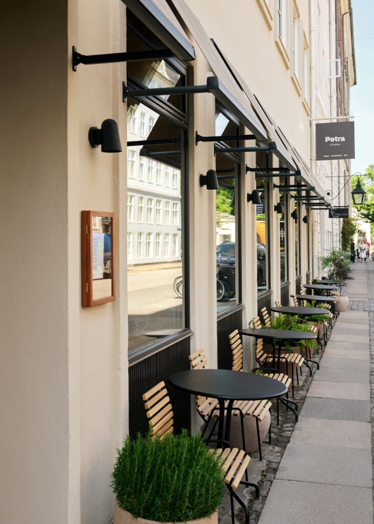 Bänkar på uteservering utanför ett hotell.