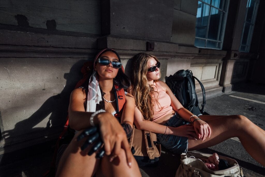 Två flickor sitter på golvet på fransk järnvägsstation