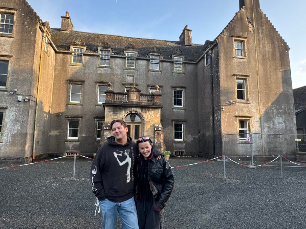 Christopher Garplind och Miriam Bryant står framför en liten skotsk borg.