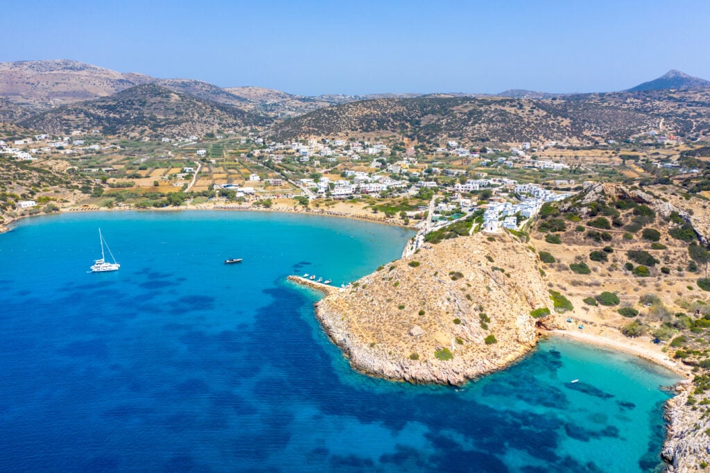 En klippig udde sträcker sig ut i ett turkost hav, drönarvy.