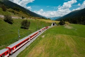 Rött tåg i bergigt landskap.