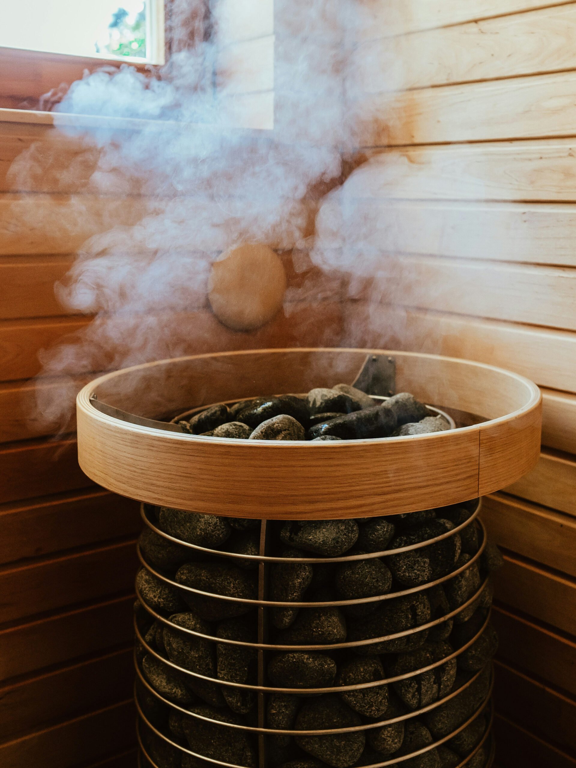 Ett runt bastuaggregat ångar i ett hörn av en bastu.