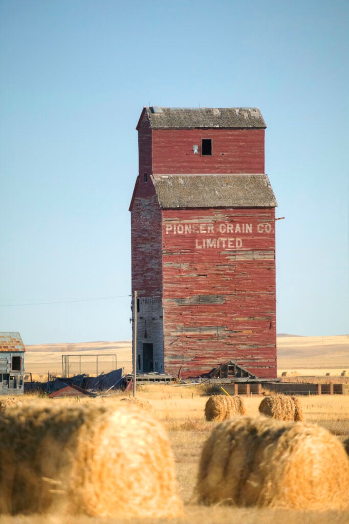 En gammal, väderbiten träsilo på prärien.