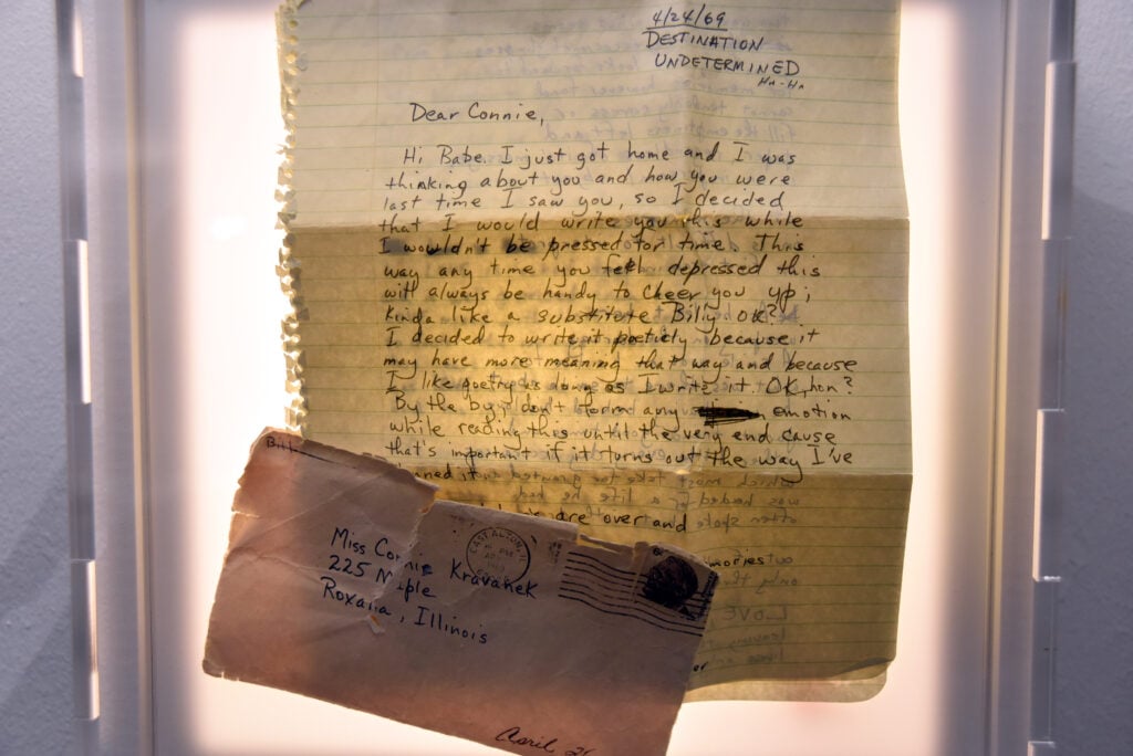 Ett handskrivet brev och ett kuvert på en upplyst display.