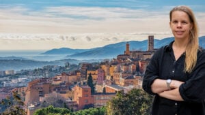 En utsiktsvy över en stad med medeltida arkitektur, som sticker upp framför ett dramatiskt bergslandskap och en havskust.