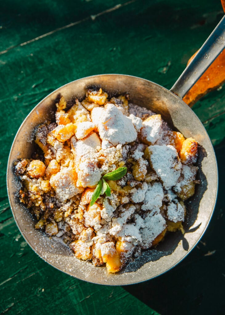 En tallrik ovanför med smulig pannkaka täckt i florsocker. 