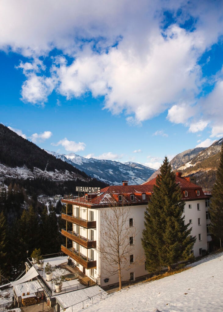 En vit hotellbyggnad i en alpdal. 