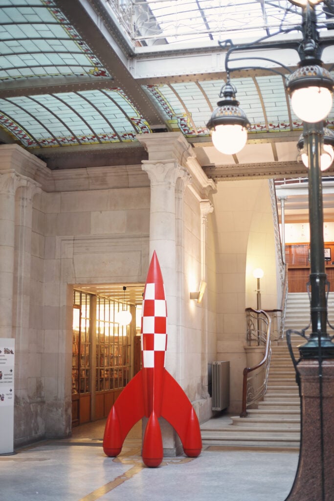 En skulptur av en serieteknad raket, rutig i rött och vitt.