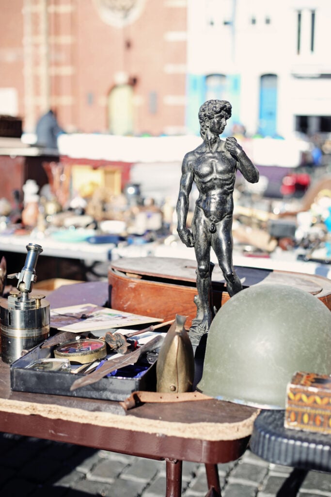 Loppisfynd trängs på ett bord i solskenet.