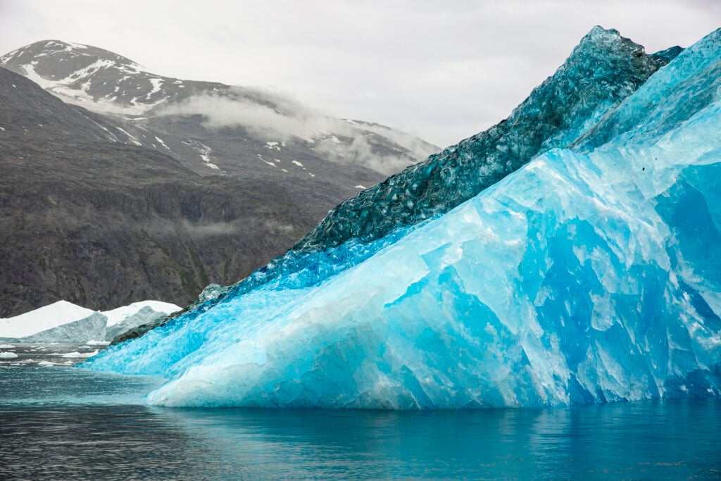 Två blå isberg flyter i havet.