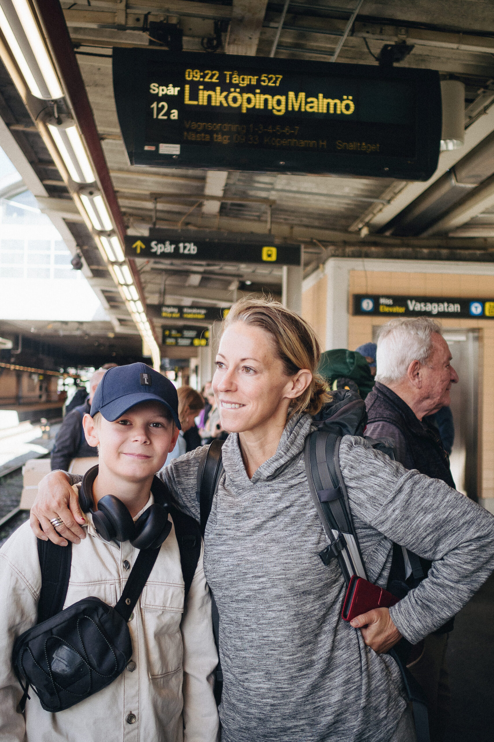 Mamma och son på järnvägsstation.