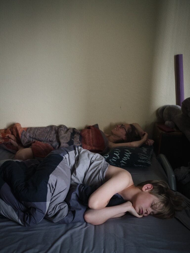 Mamma och barn som sover i gästsäng.