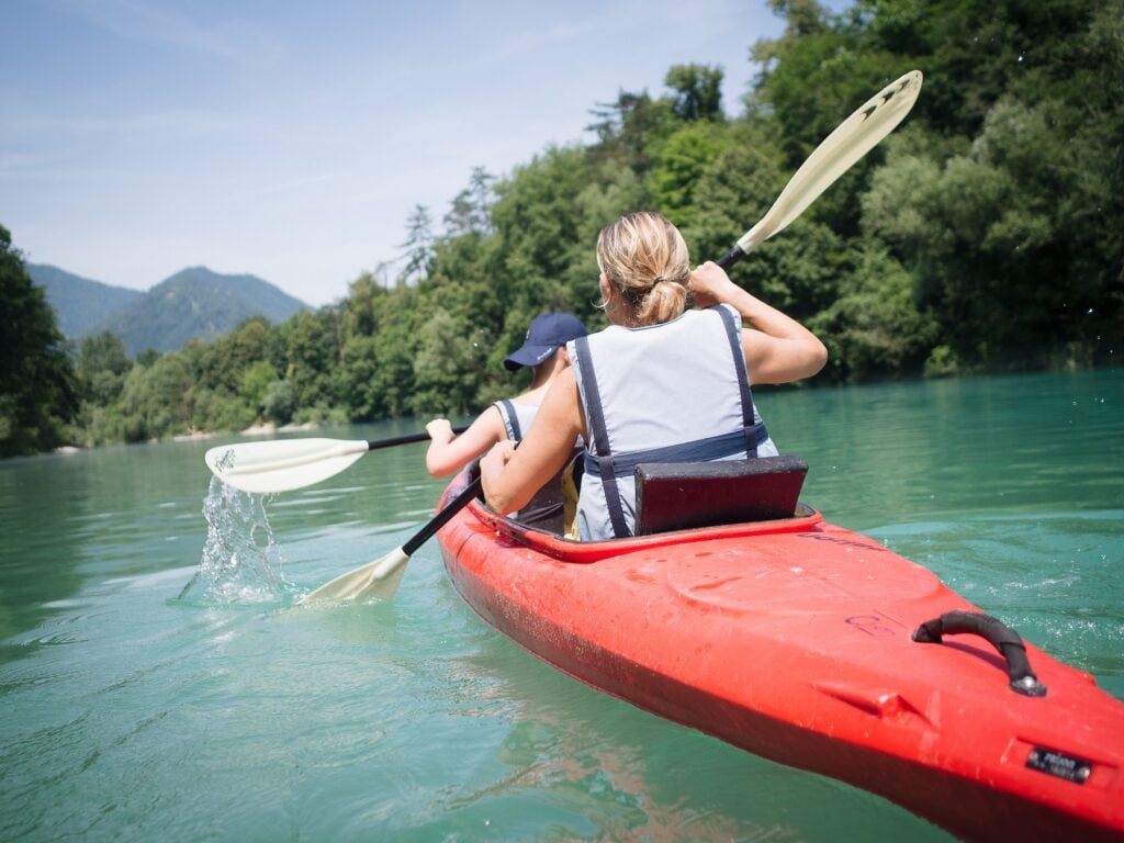 Mamma som paddlar kajak med sin son.