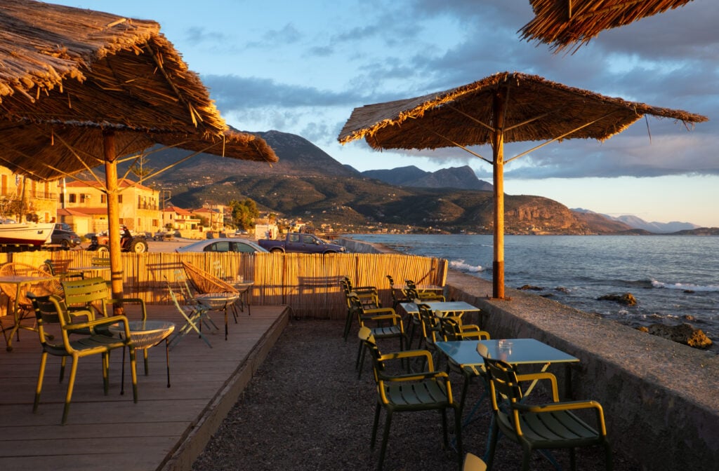 En solbadande uteservering precis vid havet i solnedgången.