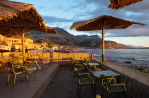 En solbadande uteservering precis vid havet i solnedgången.