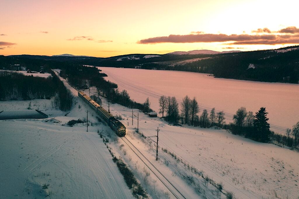 Tåg som kör genom snöigt landskap.