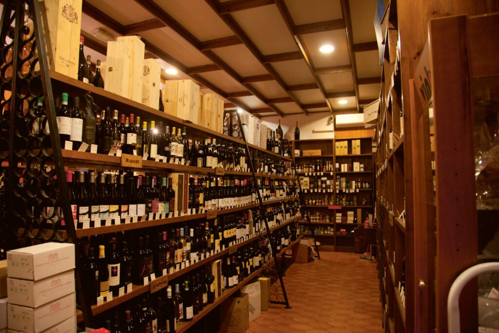 Ett rum fyllt med vinflaskor. Bruna hyllor.