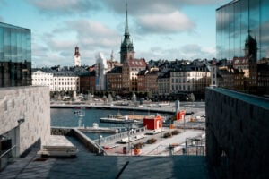 En vy över Stockholms gamla stad med en bred gångbro och vatten, en del vägarbete pågår.