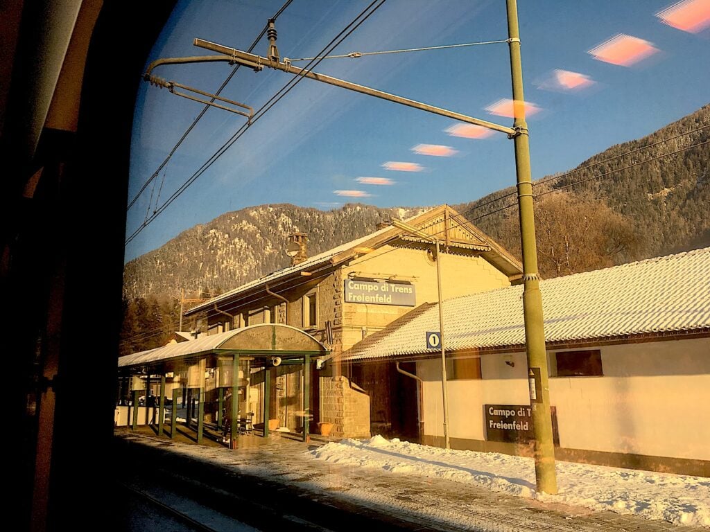 Tågstation sedd genom tågfönster.