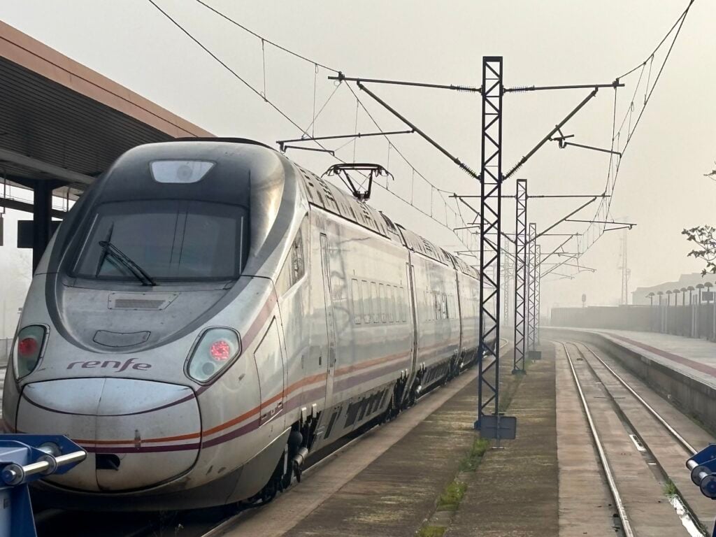 Snabbtåg vid perrongen i morgondimma.