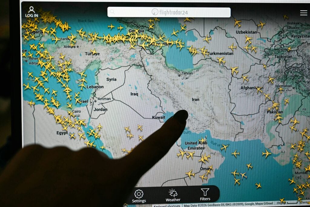 Ett finger pekar på en datorskärm med massa flygplan.