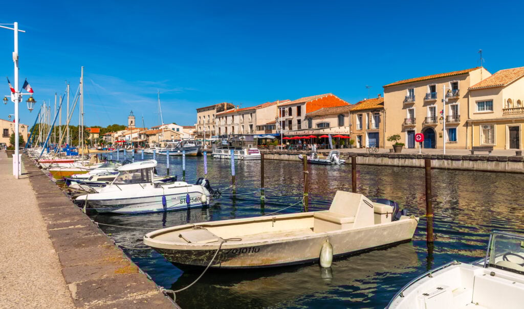 Båtar ligger förtöjda i en kanal.