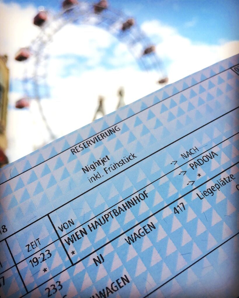 Tågbiljett Wien-Padova med pariuserhjul i bakgrunden.