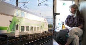 Finskt grönvitt tåg och kvinna i sovvagnskupé som tittar ut genom tågfönstret.