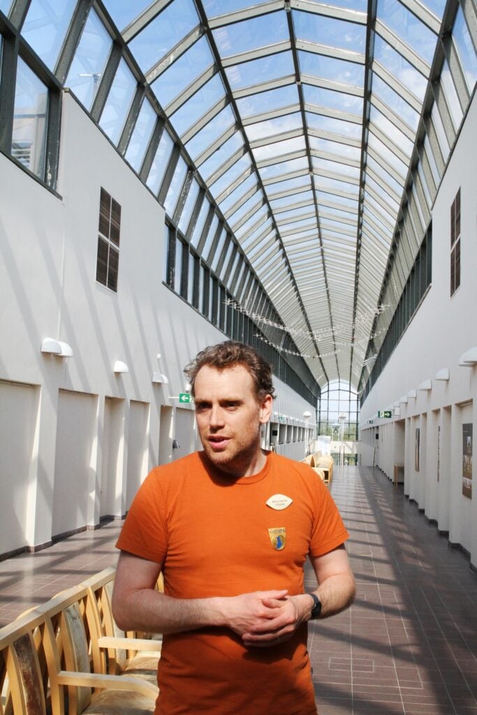 Man i orange tröja på atriumgård.