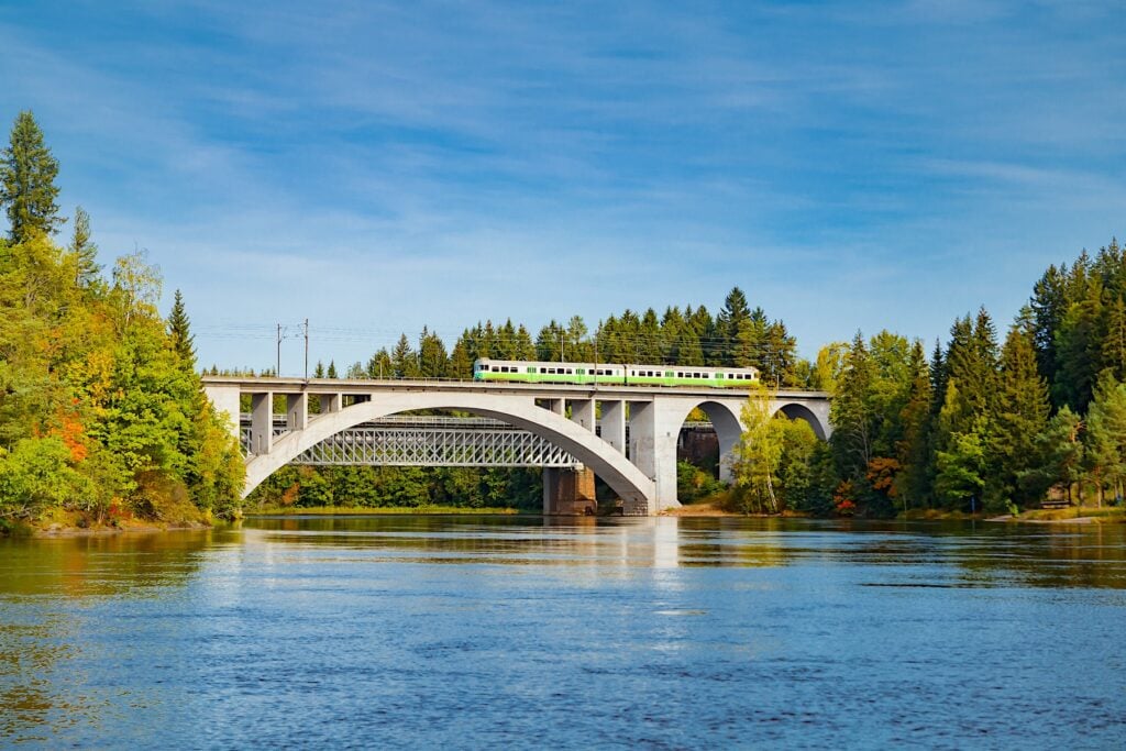Finskt tåg på bro över älv.