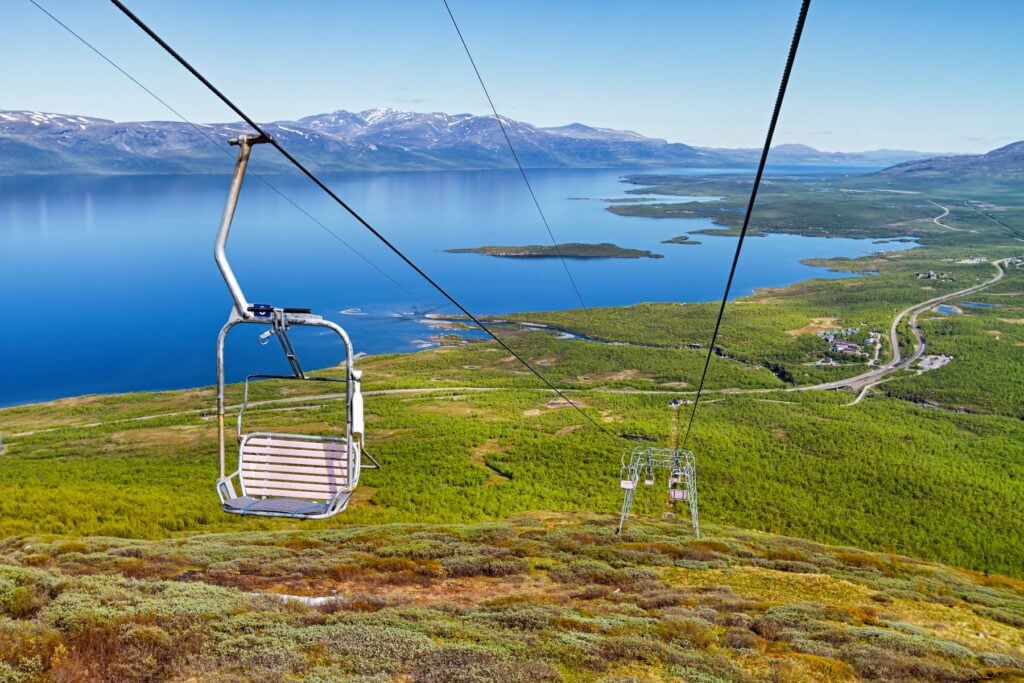 Skidlift med skog och sjö i bakgrunden.