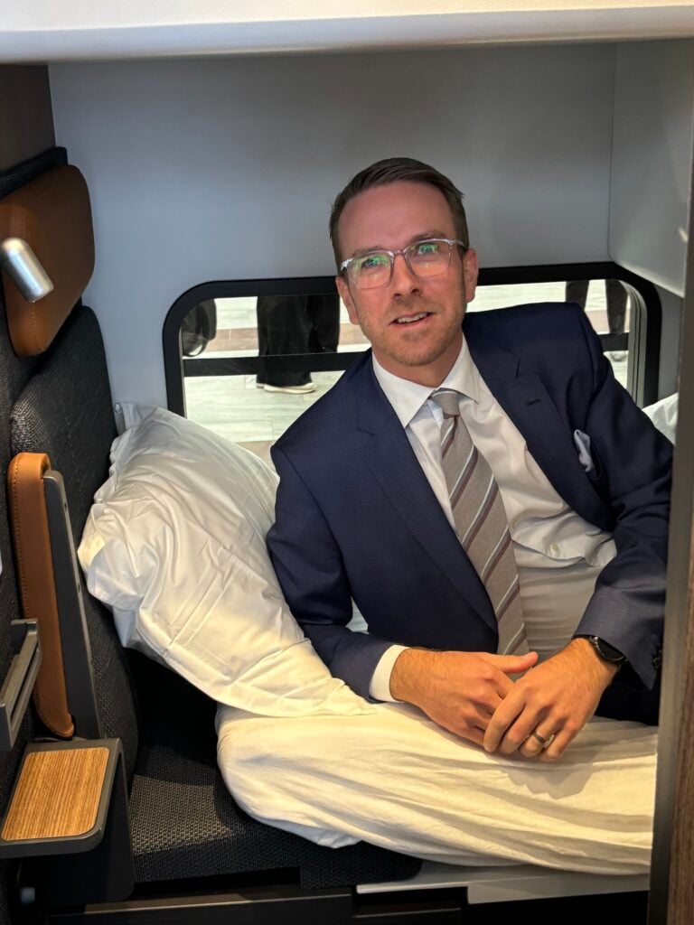 Minister i kostym testar nya sovkupéerna på tåg.