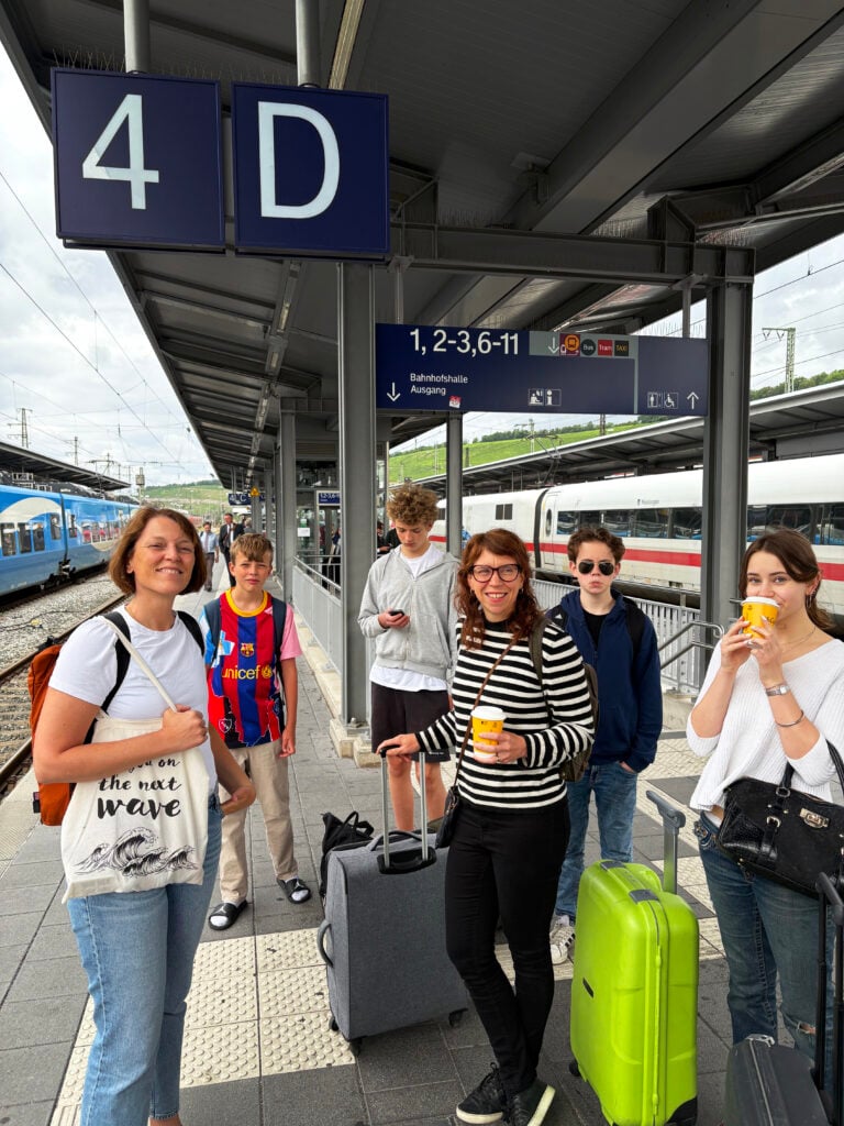 En grupp människor står på en tågperrong med resväskor och ser förvirrade ut. 