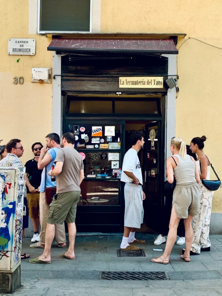 Bargäster på gatan utanför en spansk vermuteria