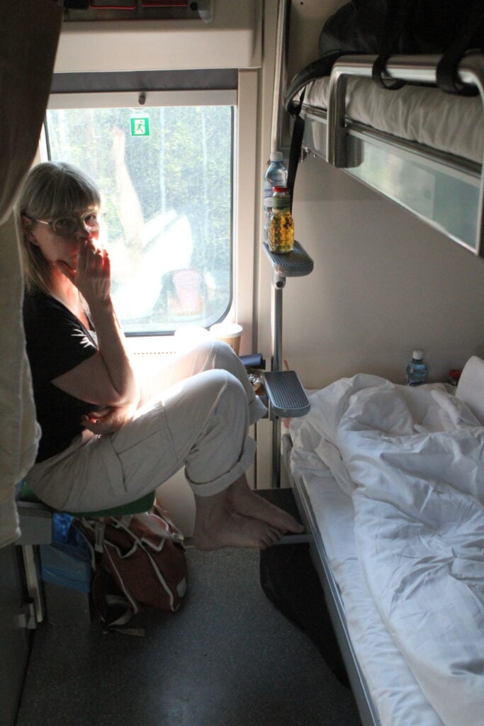 Kvinna sitter i sovkupé på tåg.