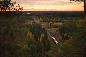 Train moving on track amidst scenic landscape at sunset