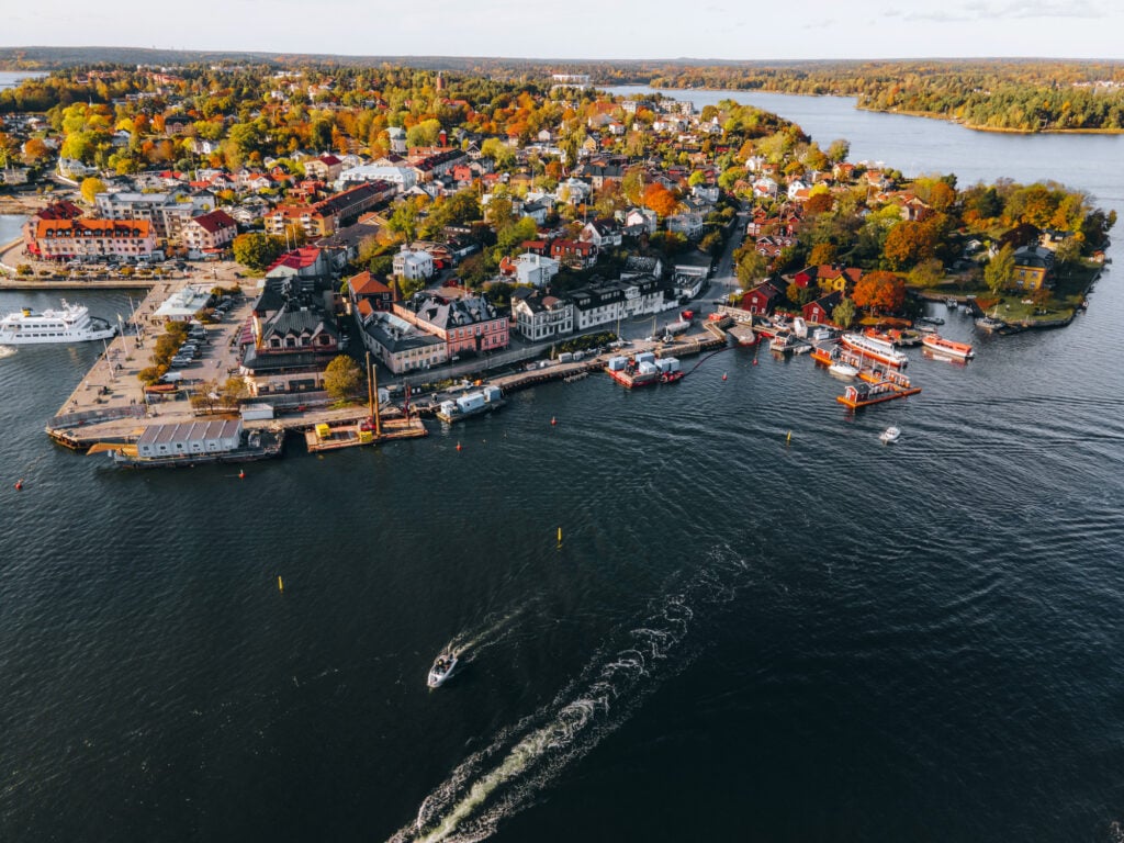 Flygvy över en småstad vid havet, båtar, solbedgång,