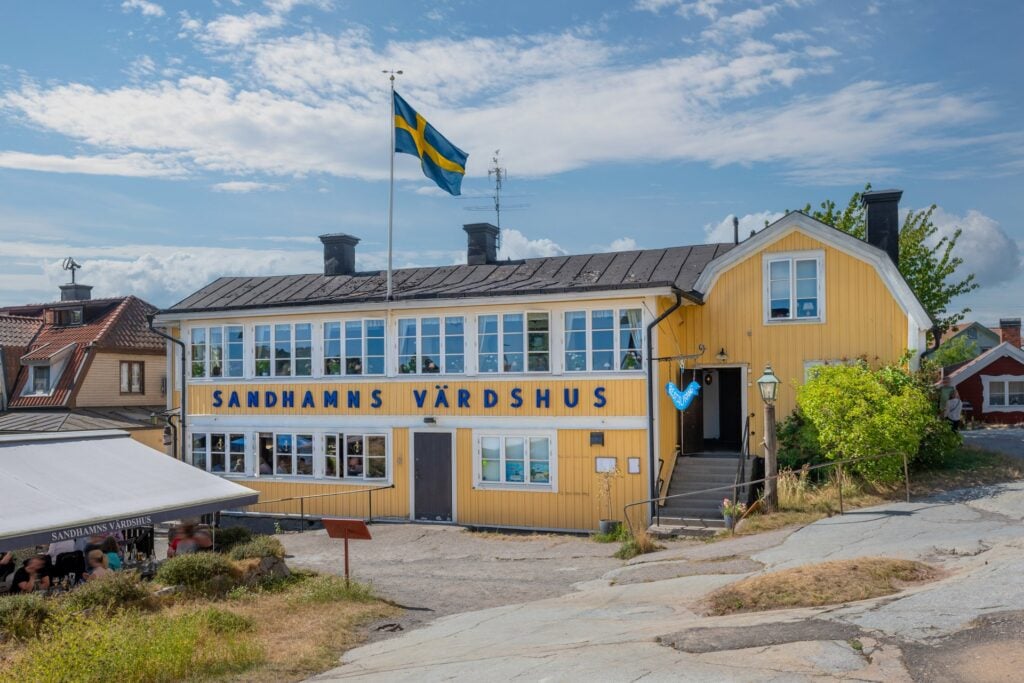 Ett gult hus på klippor. 