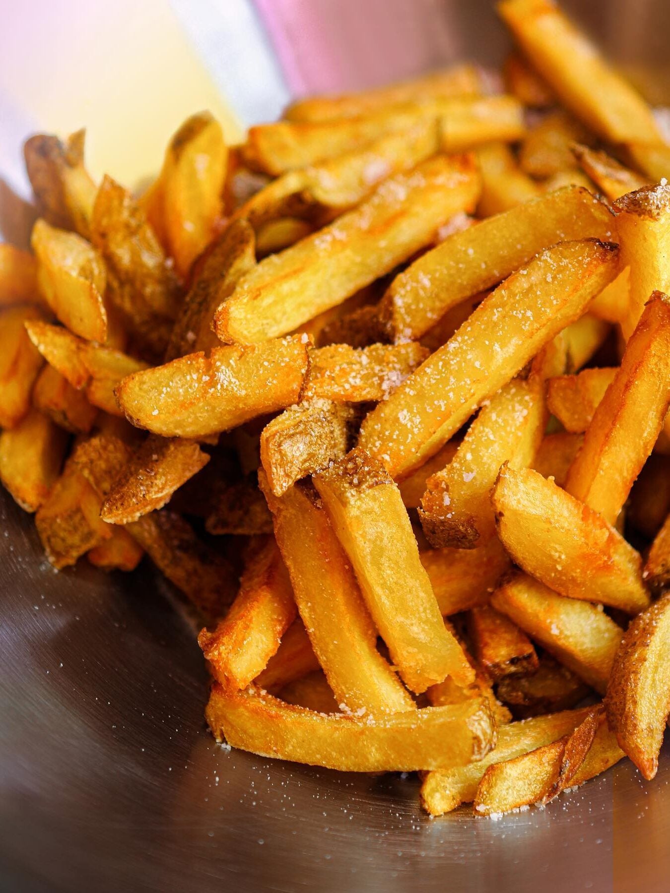 Närbild på frasiga pommes frites på ett bord. 
