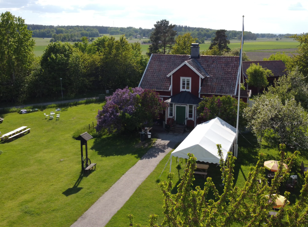 Flygbild av rött hus med vita knutar