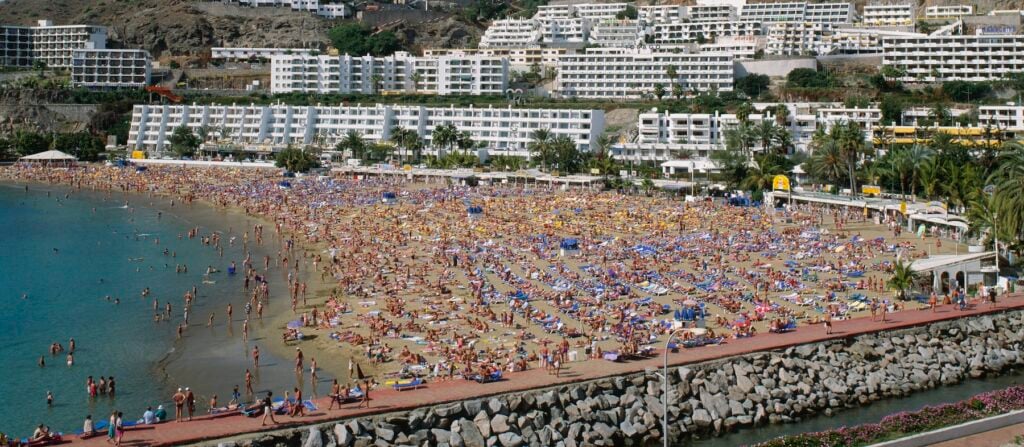 Strand fullproppad med solbadare