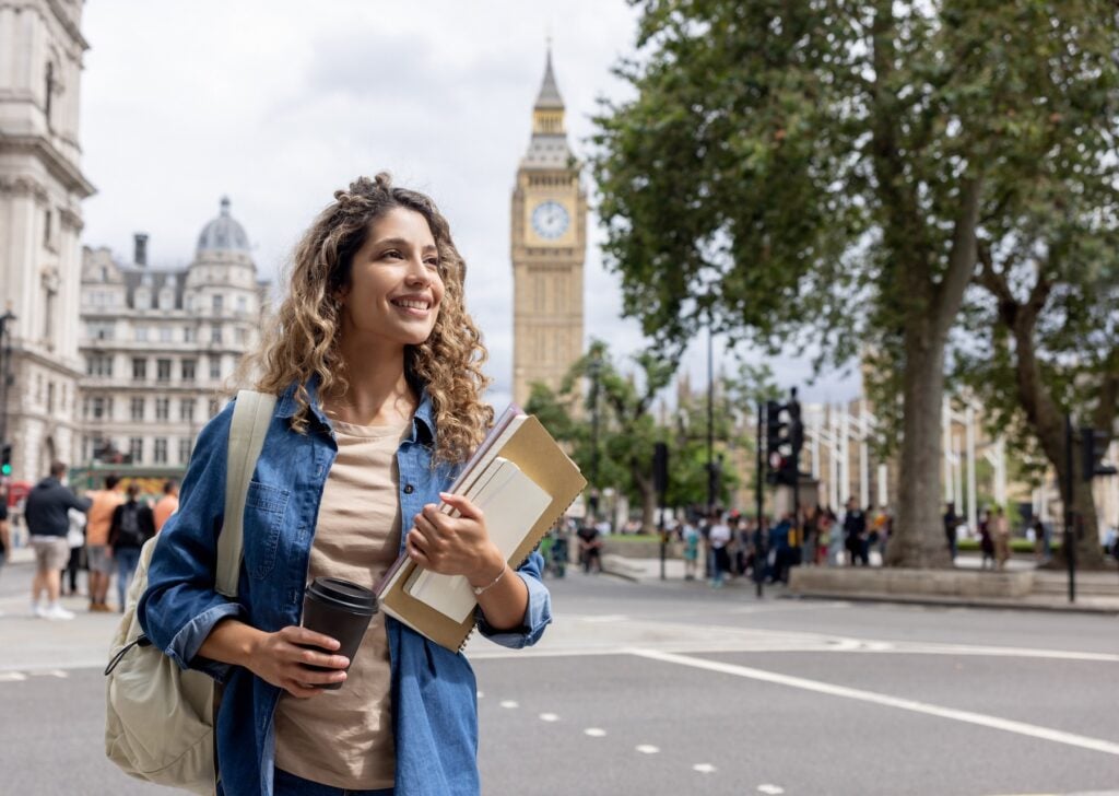 Kvinna med papper i handen framför Big Ben i London.