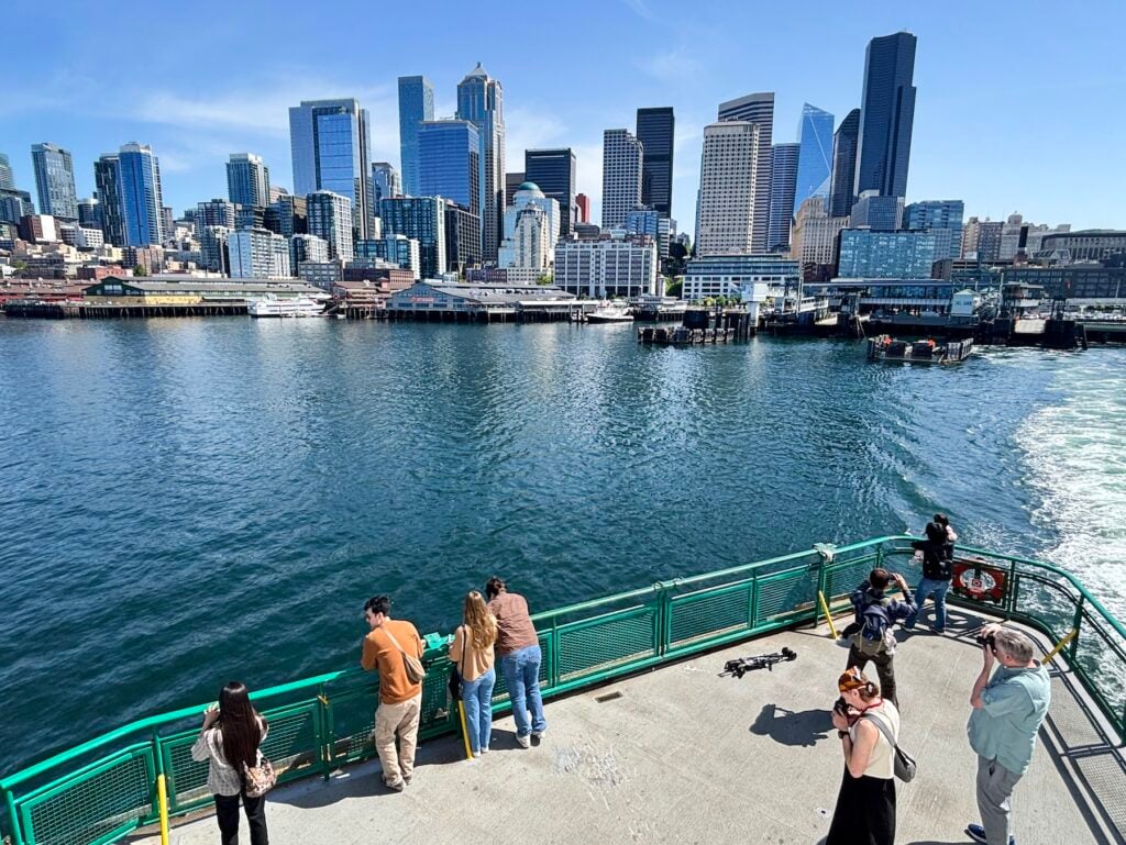 Färja med passagerare och skyline av Seattle i bakgrunden.
