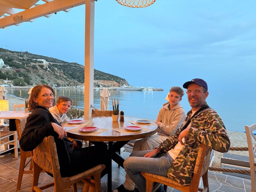 Familj med två barn på taverna med havsutsikt.