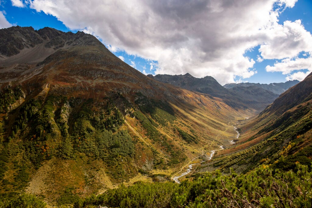 En vacker vy över en bergsdal med en slingrande å i mitten.