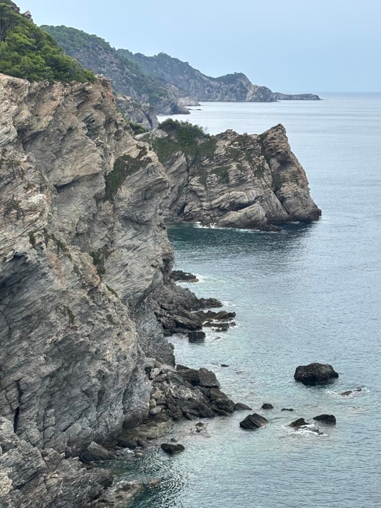 Gråa kraftiga klippor ovanför havet. 