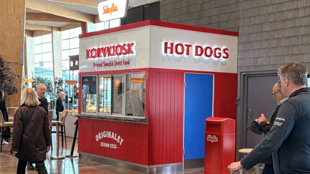 En röd korvkiosk inne på en flygplats.