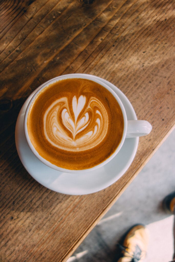 En vit kaffekopp ovanifrån med latte-konst.